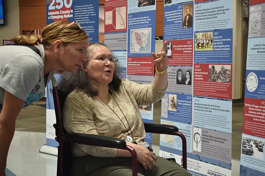 Jody Turnquist and Silvana Capello browse the historical timeline.