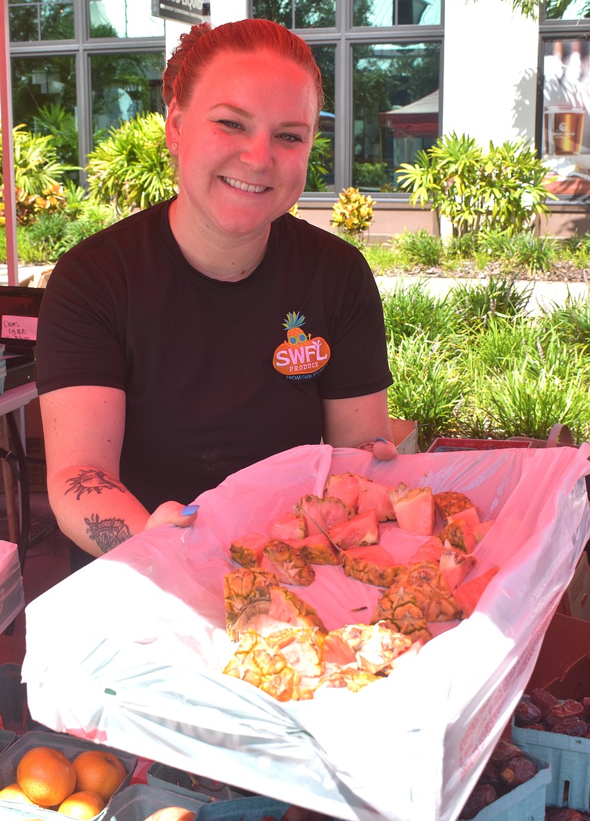 Brittany Snyder, the market manager of Southwest FL Produce, hands out free samples of  pink pineapple at the Farmers' Market at Lakewood Ranch.