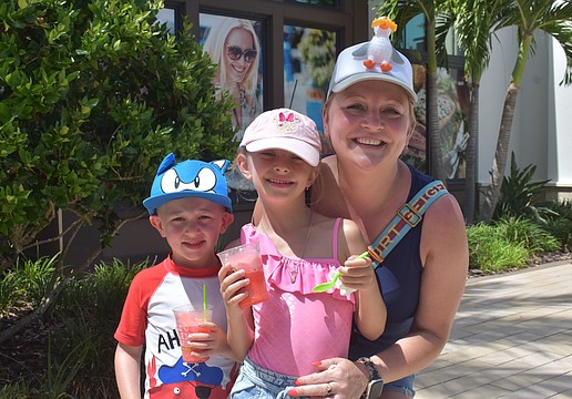 Boston's JJ Maguire, 4, Ariel Maguire, 6, and their mom, Kasha Grabowski, wear funky hats while enjoying treats from Jeremiah's Italian Ice at the Farmers' Market at Lakewood Ranch.