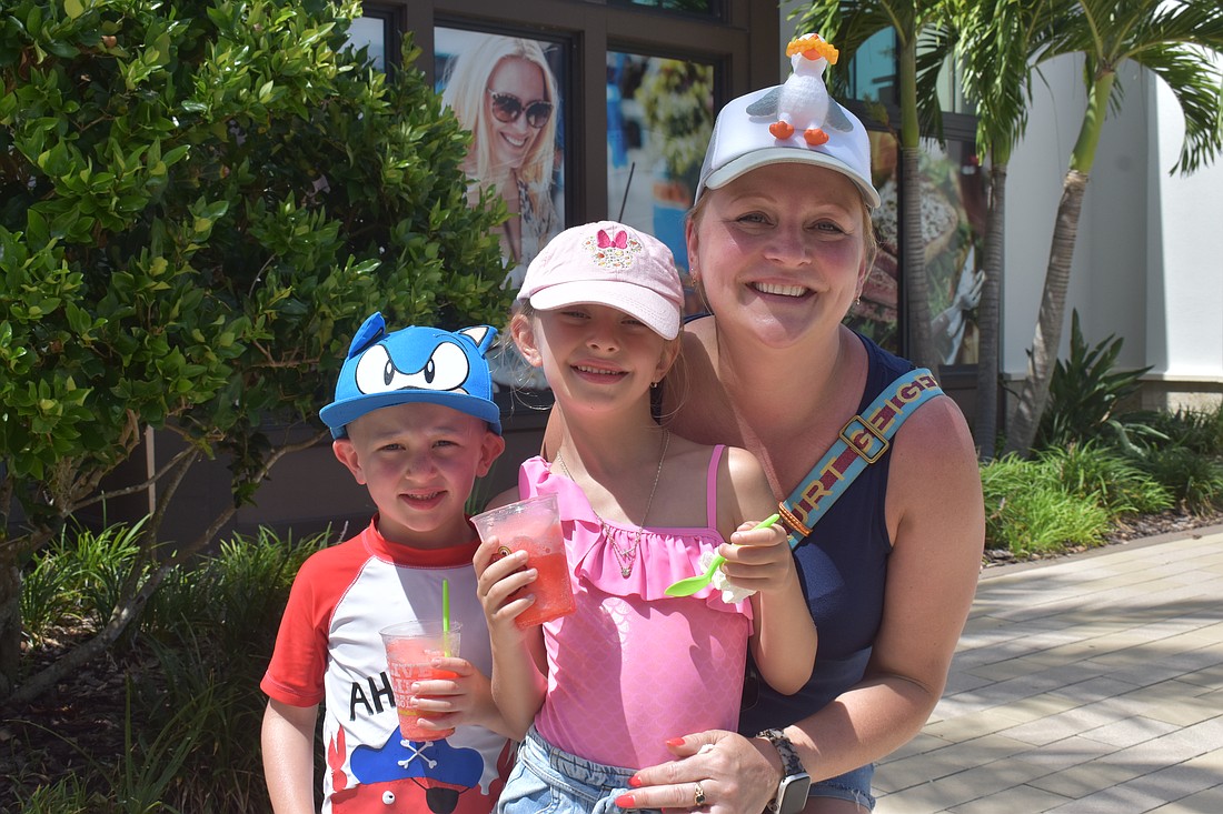 Boston's JJ Maguire, 4, Ariel Maguire, 6, and their mom, Kasha Grabowski, wear funky hats while enjoying treats from Jeremiah's Italian Ice at the Farmers' Market at Lakewood Ranch.