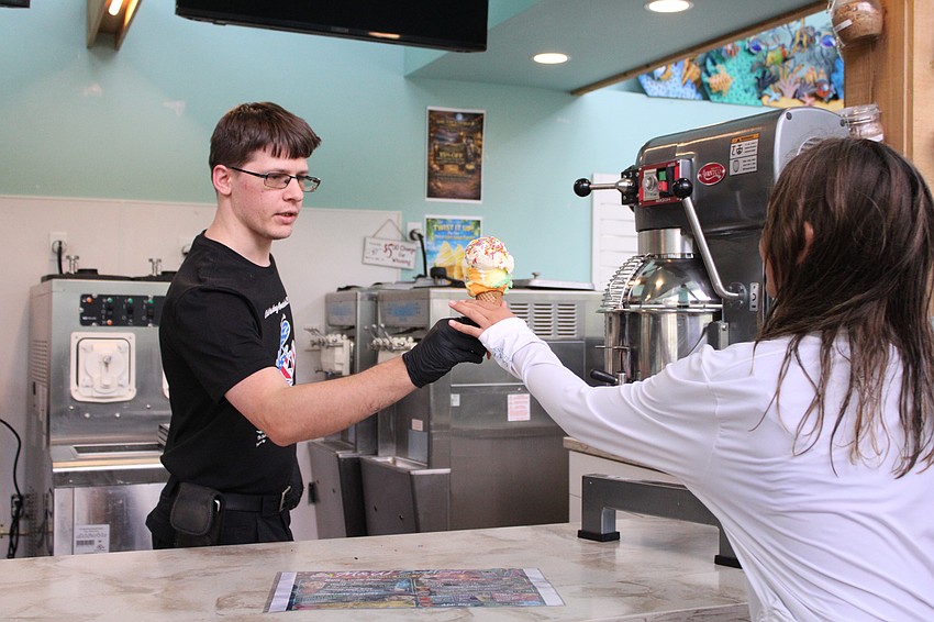 Calvin Shaw, part-owner of the new M & W Sweet Spot, serves up a cone of rainbow sherbert.