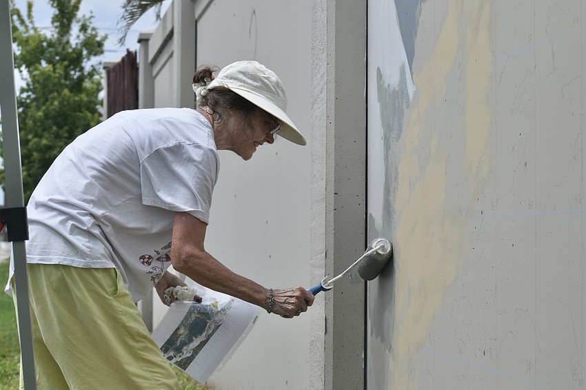 Patricia MacLean begins rolling out the paint on 