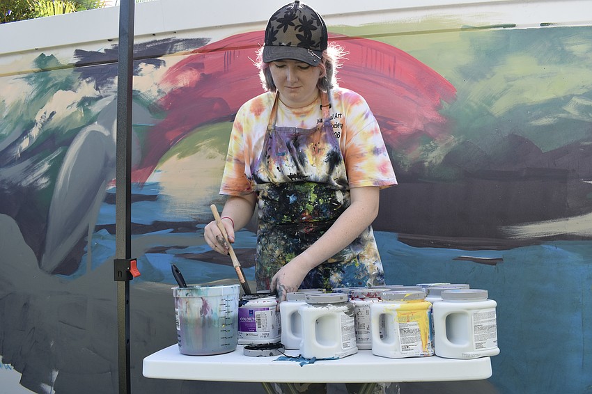 Ginger Kreithen takes a moment to gather some paint as she works on 