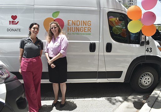 Amanda Eyer, internal communications and community relations director at Boar’s Head and Amber Lee, senior director of programs at All Faiths Food Bank, stand in front of one of the new vans.