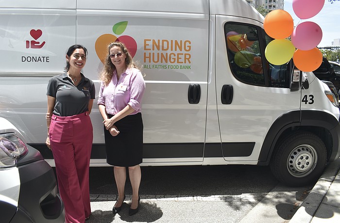 Amanda Eyer, internal communications and community relations director at Boar’s Head and Amber Lee, senior director of programs at All Faiths Food Bank, stand in front of one of the new vans.