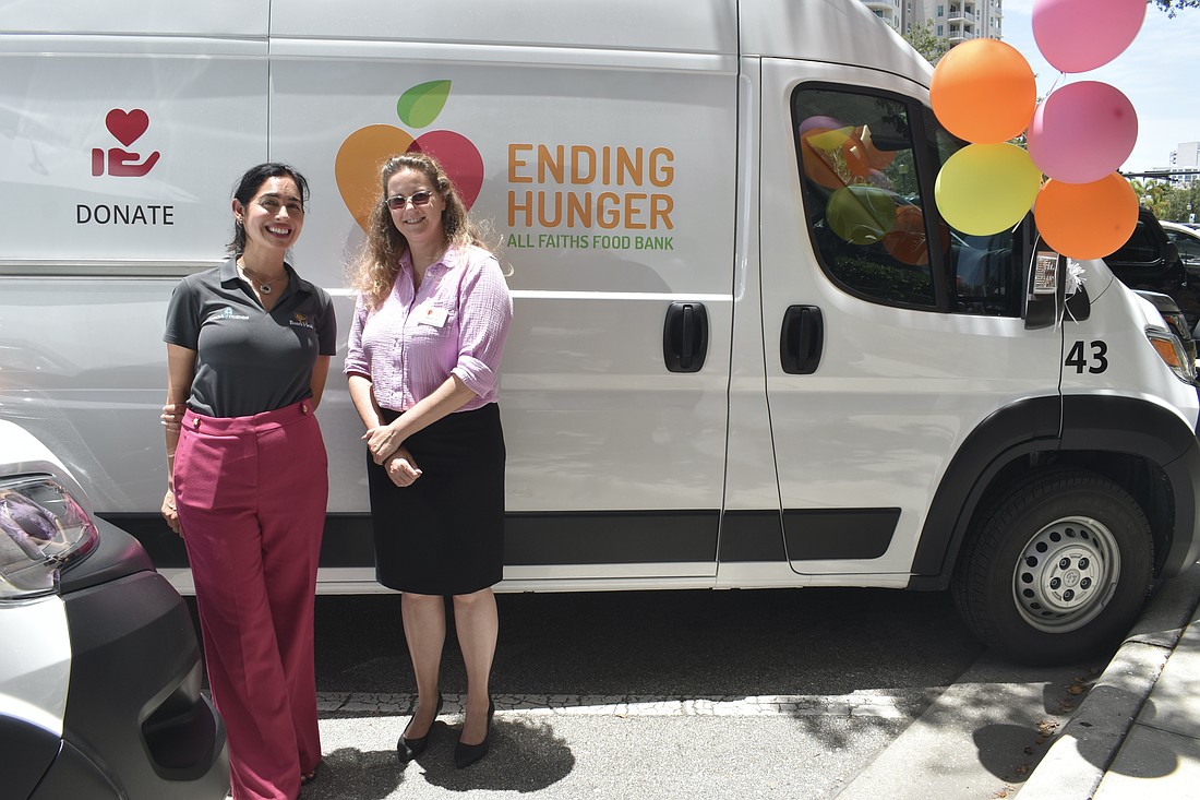 Amanda Eyer, internal communications and community relations director at Boar’s Head and Amber Lee, senior director of programs at All Faiths Food Bank, stand in front of one of the new vans.
