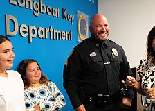 From left to right: Avery Mathis, Charlie Mathis, Michael Mathis and Jessica Mathis grin at a badge pinning ceremony where Michael Mathis was promoted to sergeant of the Longboat Key Police Department.