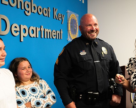 From left to right: Avery Mathis, Charlie Mathis, Michael Mathis and Jessica Mathis grin at a badge pinning ceremony where Michael Mathis was promoted to sergeant of the Longboat Key Police Department.