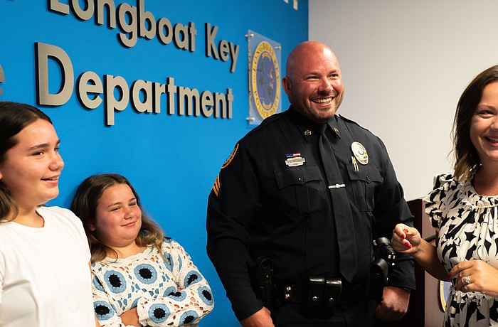 From left to right: Avery Mathis, Charlie Mathis, Michael Mathis and Jessica Mathis grin at a badge pinning ceremony where Michael Mathis was promoted to sergeant of the Longboat Key Police Department.