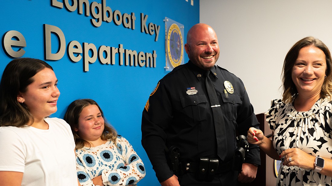 From left to right: Avery Mathis, Charlie Mathis, Michael Mathis and Jessica Mathis grin at a badge pinning ceremony where Michael Mathis was promoted to sergeant of the Longboat Key Police Department.