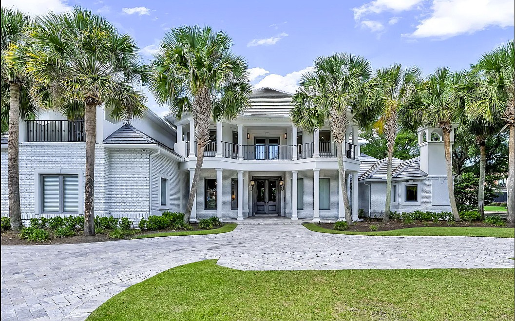 Intracoastal Waterway access two-story home features seven bedrooms, 10 full and one half-bathrooms, wine cellar, sauna, porches, patio, outdoor kitchen, pool, dock and four-car garage.