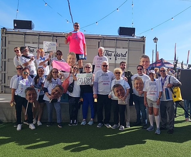 Family and friends cheer on Vinny O'Shaunessy at a marathon.