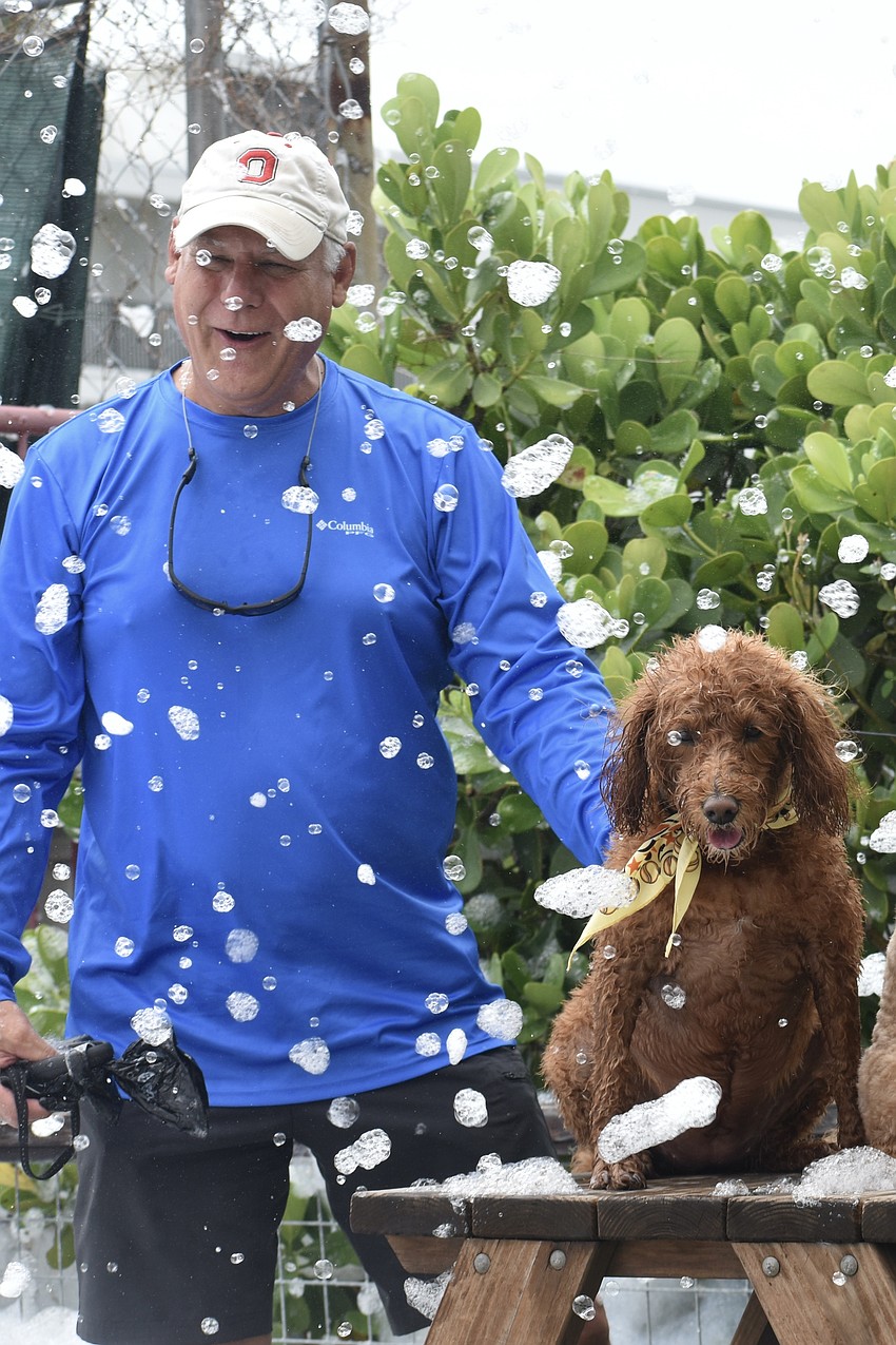Scott Hilenski enjoys the raining foam with his dog Zoey.