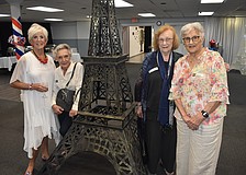 Helen Hreen, Alliance Française de Sarasota president; Catherine White Barbara Frey and Maggie Edwy stand beside a replica of the Eiffel Tower at Bastille Day.