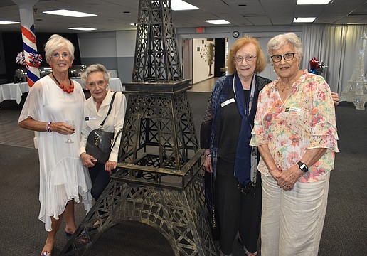 Helen Hreen, Alliance Française de Sarasota president; Catherine White Barbara Frey and Maggie Edwy stand beside a replica of the Eiffel Tower at Bastille Day.
