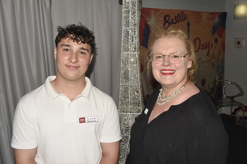 Louis Gallois and Miriam Kramer, past president of Sister Cities Association of Sarasota, stand beside a replica of the Eiffel Tower at Bastille Day.