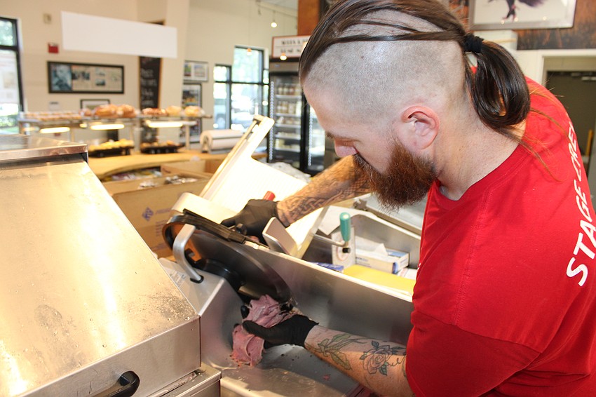 Employee Joel Hanson gets a pile of meat ready for a Wolfie's sandwhich.