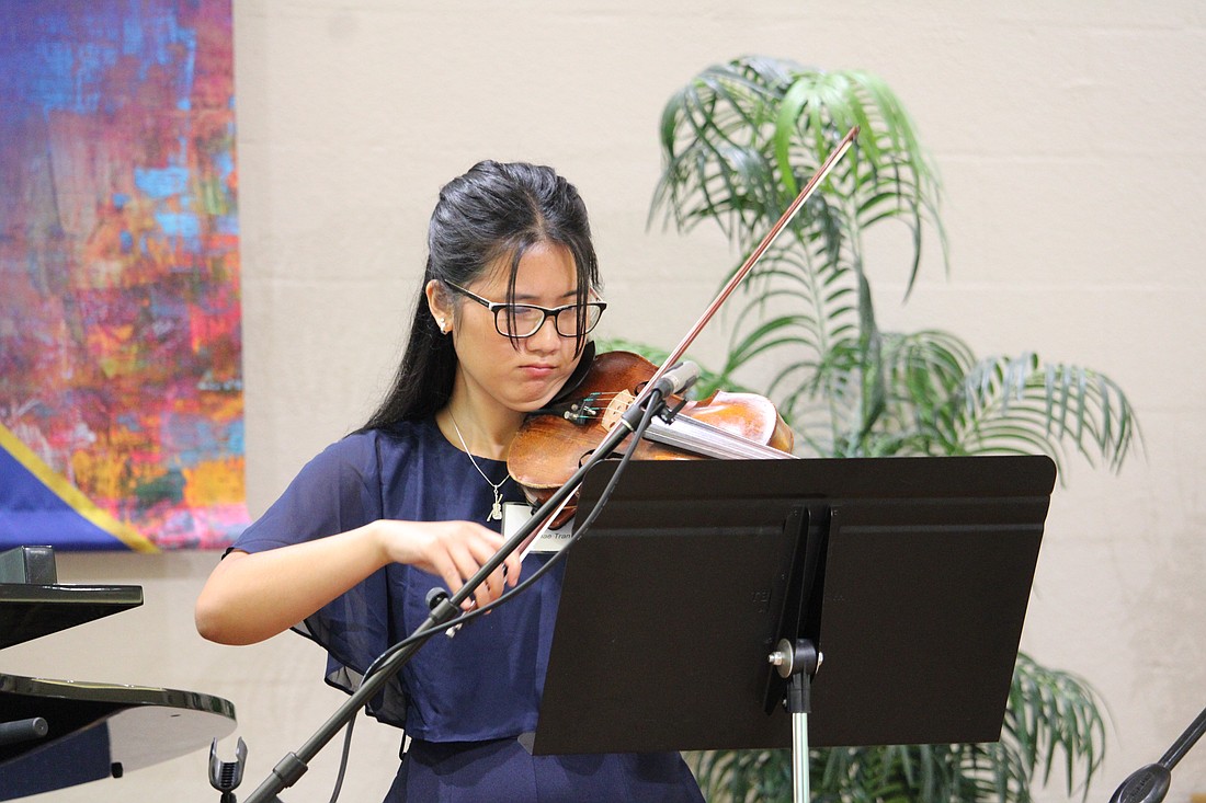 Danae Tran plays the violin for Longboat Island Chapel attendees of the July 19 morning service before she and fellow scholarship recipient Michelle McLeod move to greet guests at the award reception.