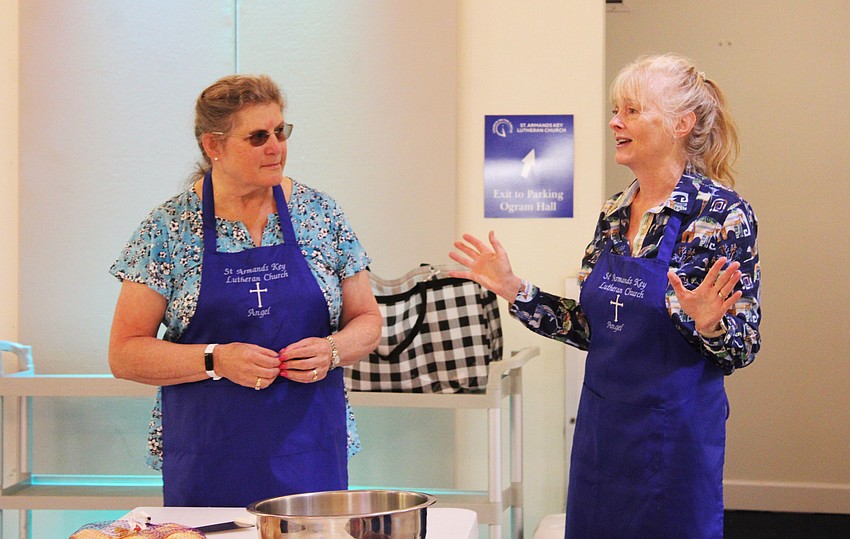While Juli Kampe listens, Karyn Smith gives instructions on the different workstations for food prep that morning.