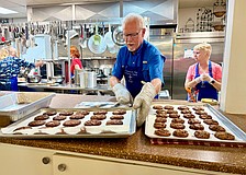 Ernie Smith lines up trays of freshly baked chocolate chip cookies for lunch at Resurrection House. He and nine other volunteers prepared a meal on July 23 as one of St. Armands Key Lutheran Church's monthly charitable events.