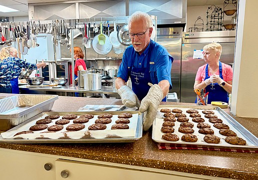Ernie Smith lines up trays of freshly baked chocolate chip cookies for lunch at Resurrection House. He and nine other volunteers prepared a meal on July 23 as one of St. Armands Key Lutheran Church's monthly charitable events.