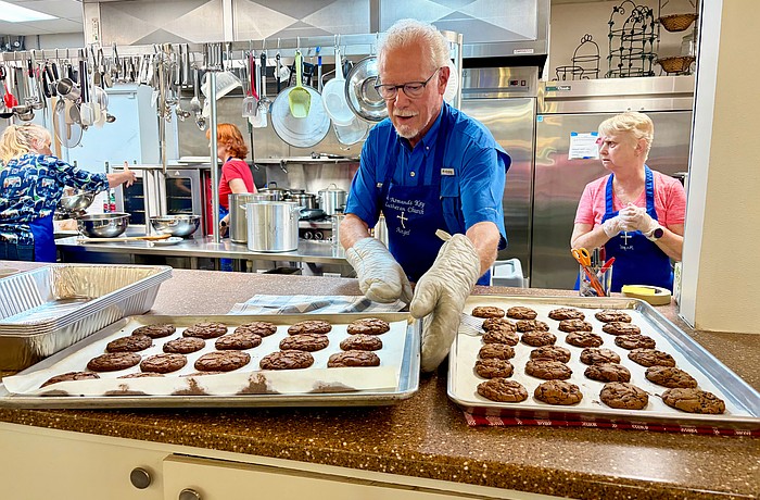 Ernie Smith lines up trays of freshly baked chocolate chip cookies for lunch at Resurrection House. He and nine other volunteers prepared a meal on July 23 as one of St. Armands Key Lutheran Church's monthly charitable events.