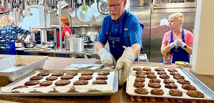 Ernie Smith lines up trays of freshly baked chocolate chip cookies for lunch at Resurrection House. He and nine other volunteers prepared a meal on July 23 as one of St. Armands Key Lutheran Church's monthly charitable events.