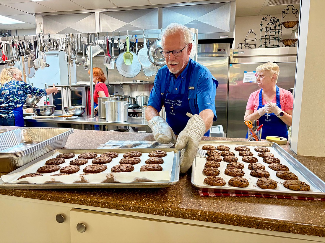 Ernie Smith lines up trays of freshly baked chocolate chip cookies for lunch at Resurrection House. He and nine other volunteers prepared a meal on July 23 as one of St. Armands Key Lutheran Church's monthly charitable events.