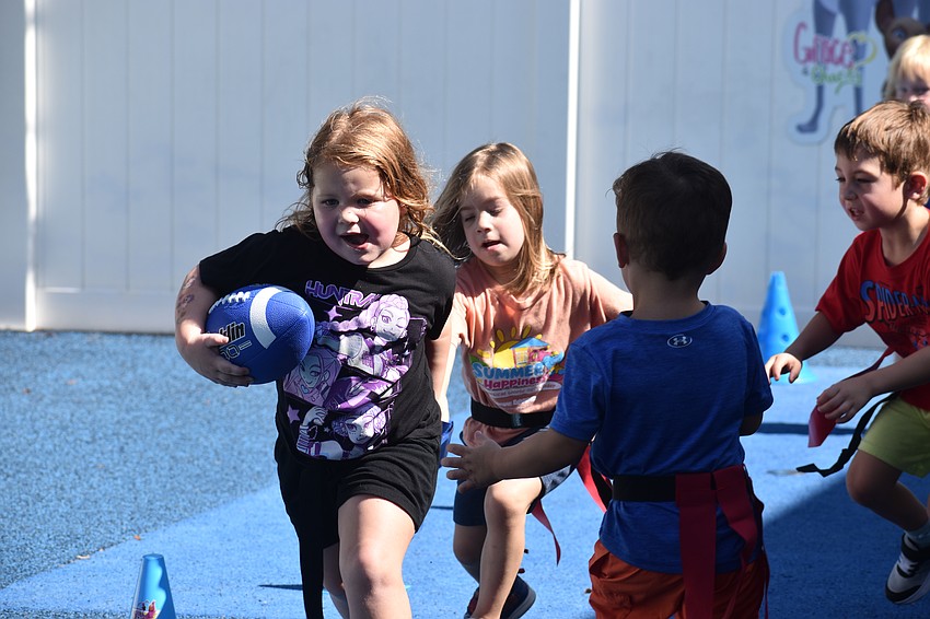 Lakewood Ranch's Aurora Martinez, 4, zig zags her way through her opponents during flag football at The Learning Experience.