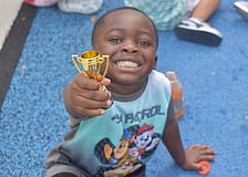 Bradenton 3-year-old Zy'heir Curry, a lover of "Paw Patrol," shows off his trophy from playing flag football at The Learning Experience.