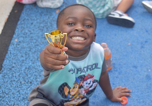 Bradenton 3-year-old Zy'heir Curry, a lover of "Paw Patrol," shows off his trophy from playing flag football at The Learning Experience.