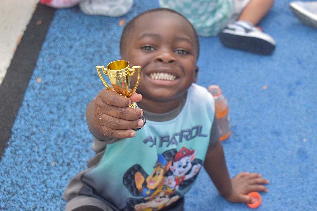 Bradenton 3-year-old Zy'heir Curry, a lover of "Paw Patrol," shows off his trophy from playing flag football at The Learning Experience.