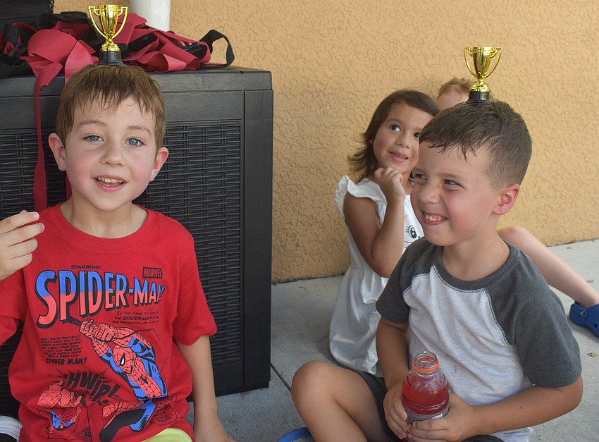 East County's Giovanni Starling and Nicholas Peters, both 4 years old, practice their balancing skills after receiving trophies for flag football.