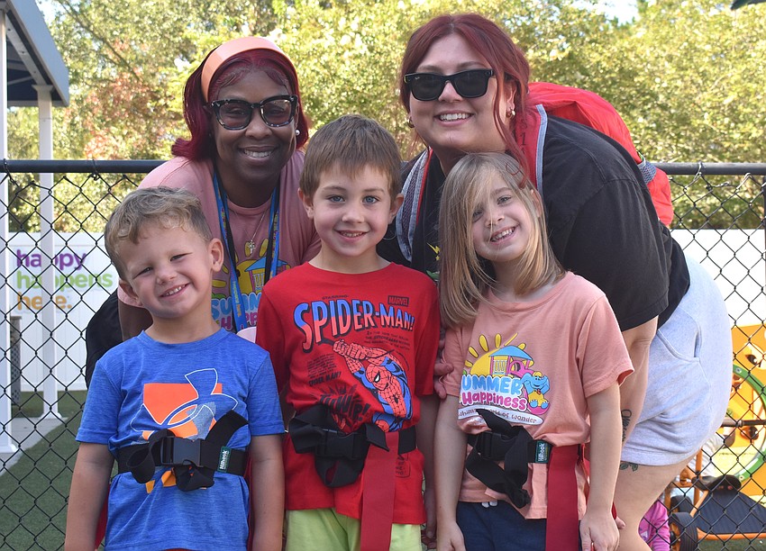 The Learning Experience Preschool Teachers Lacrecha Smalls and Kate Martinez (back) prepare their students, Camden Casey, Giovanni Starling and Caitlyn Knapp, for the start of the flag football game.