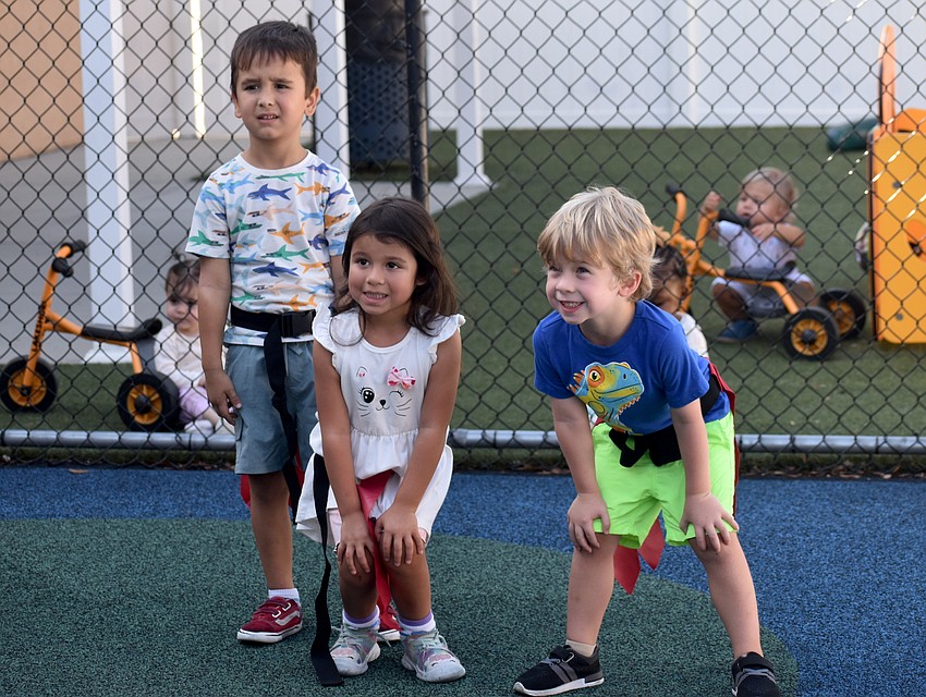 East County's Christian Haberlein, Julie Quiros and Rowan Walker, all 4 years old, get ready for their next play in The Learning Experience's flag football event July 23.
