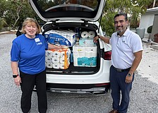 Linda Berman and Javier Chero, board members with Stillpoint Mission, pack their car to the brim with donations of toilet paper for one of Longboat Island Chapel's most popular charity drives. Even more rolls were waiting.