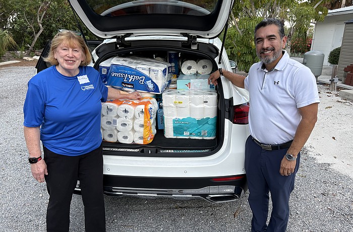 Linda Berman and Javier Chero, board members with Stillpoint Mission, pack their car to the brim with donations of toilet paper for one of Longboat Island Chapel's most popular charity drives. Even more rolls were waiting.