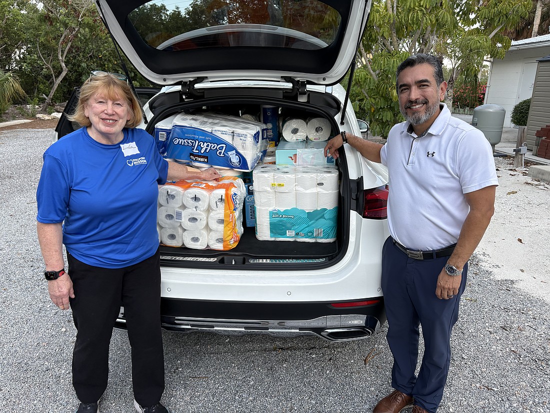Linda Berman and Javier Chero, board members with Stillpoint Mission, pack their car to the brim with donations of toilet paper for one of Longboat Island Chapel's most popular charity drives. Even more rolls were waiting.