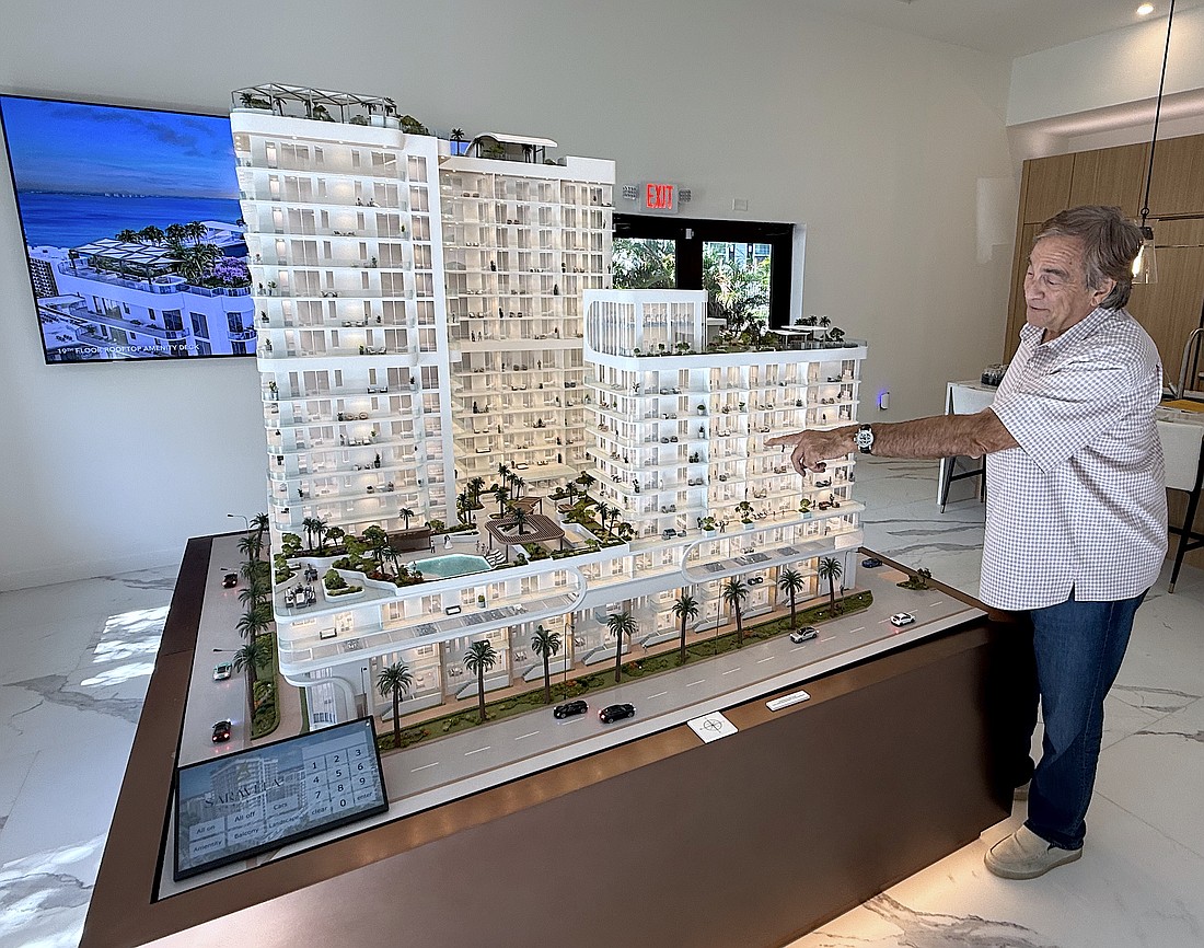 Larry Debb of GSP Development with a scale model of Saravela at the development's sales center.