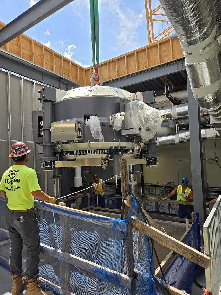 Crews lower the 55-ton superconducting synchro cyclotron into Moffitt Cancer Center's then-under construction Proton therapy center at the Speros campus in Pasco County.