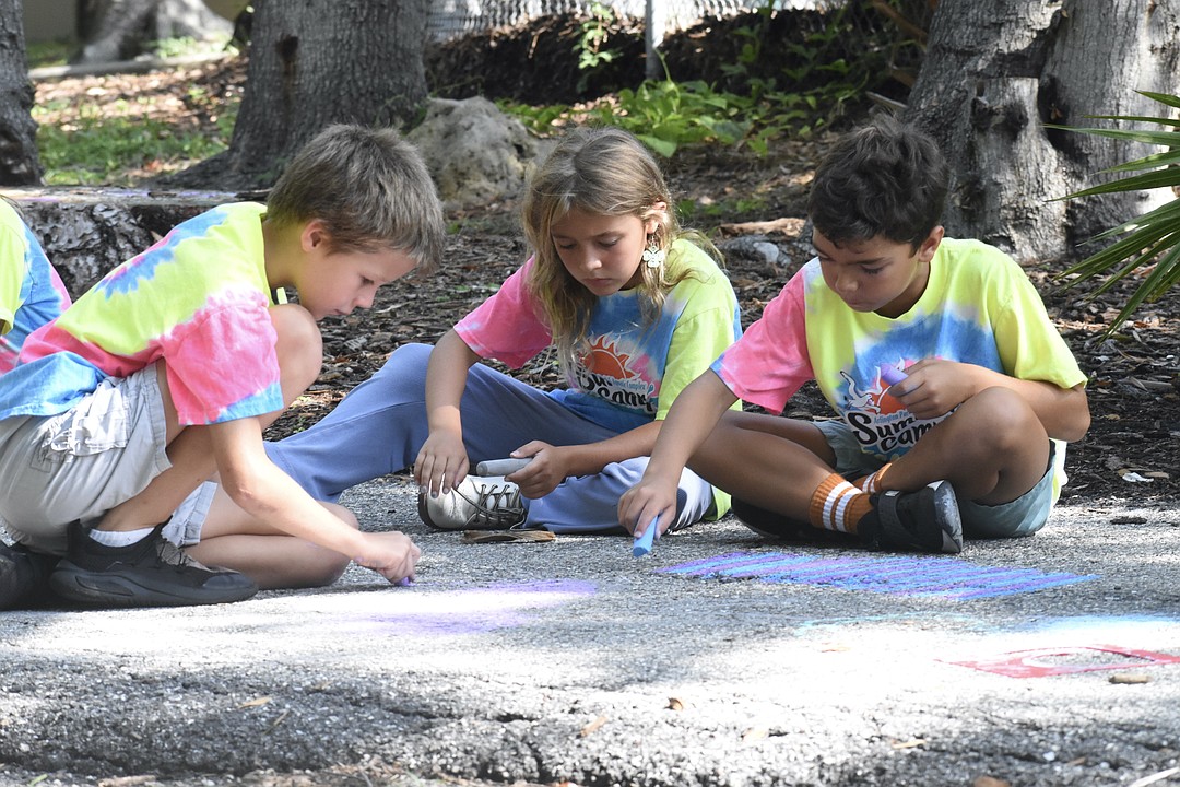Kids use sidewalk chalk to decorate the trail at Arlington Park & Aquatic Complex