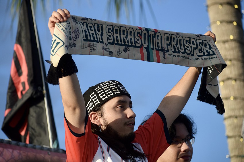 Carlos Cano hoists his scarf, which reads 