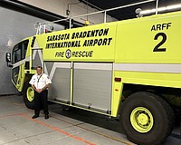 Sarasota-Bradenton International Airport Fire Department Chief Jason Hackley and one of the agency's three trucks with onboard tanks that hold 400 gallons of firefighting foam.