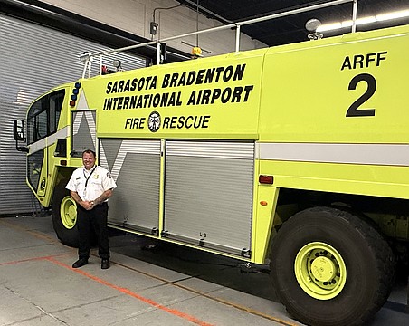 Sarasota-Bradenton International Airport Fire Department Chief Jason Hackley and one of the agency's three trucks with onboard tanks that hold 400 gallons of firefighting foam.