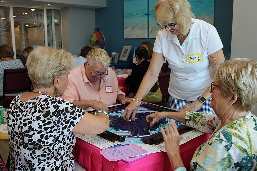 Mary Harper, Renee Fannin, Angela Bennink and Jamie Engel laugh as they set up for another mahjong game.
