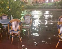 Water pooled around outdoor seating in front of Cha Cha Coconuts on the night of Thursday, July 23.