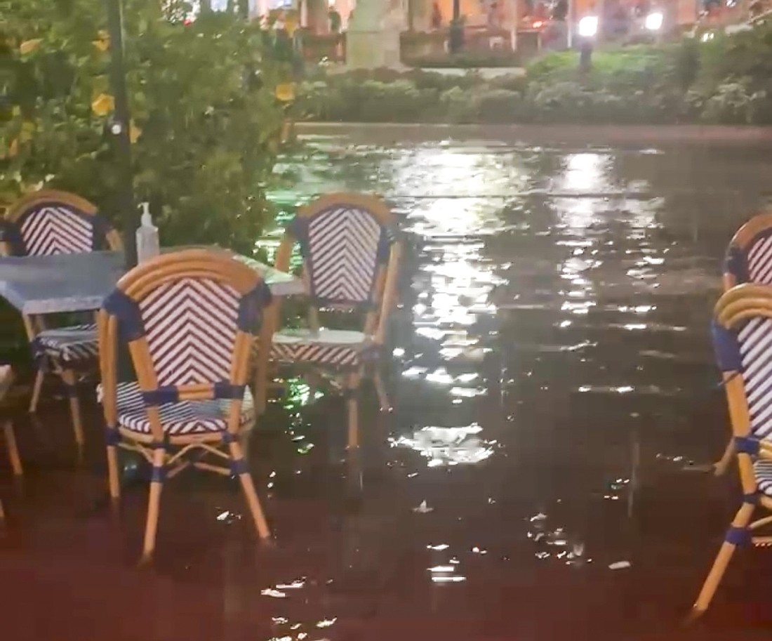 Water pooled around outdoor seating in front of Cha Cha Coconuts on the night of Thursday, July 23.