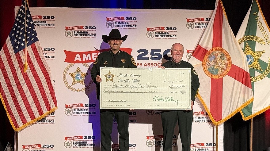 Flagler County Sheriff Rick Staly presents a donation check to Marion County Sheriff and FSYR Chairman Billy Woods, Monday, July 27, 2026, in Miami.