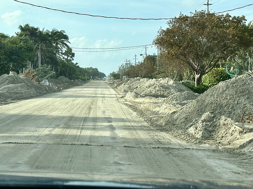 Gulf of Mexico Drive is flanked on either side by mounds of sand pushed off the road in the aftermath of Hurricane Helene in late September 2024.