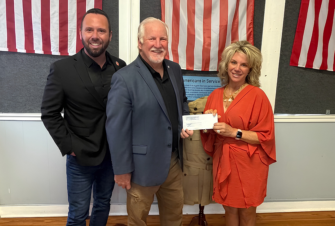 Winter Garden Heritage Foundation Executive Director and CEO Kristi Karst Gomen, right, presented a $3,500 check to Austin Arthur, chairman of Challenge 22, left, and Kurt Gies, Challenge 22 founder, following the "Patriotism on Plant" performances.